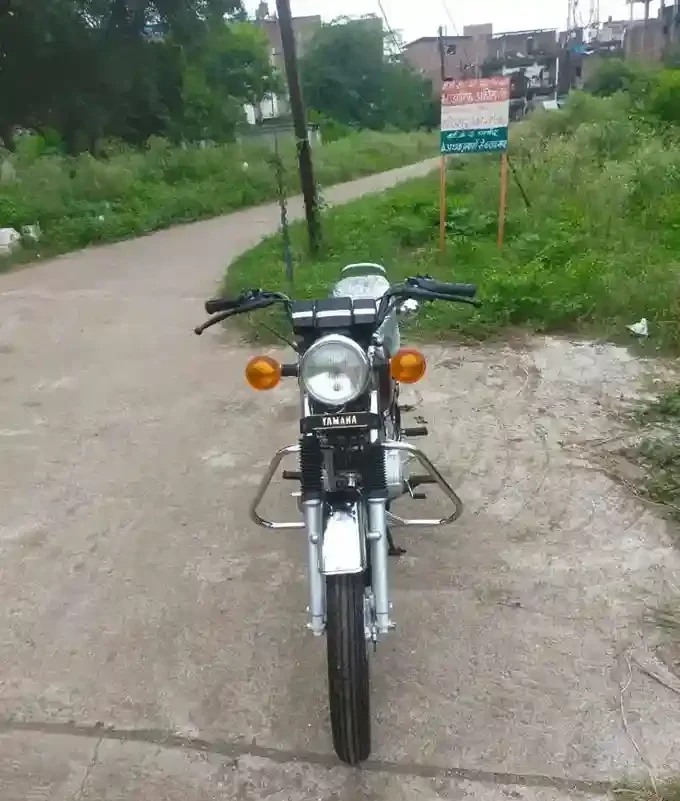 Vintage Yamaha RX100 motorcycle from 1990 with a rider sitting gracefully, highlighting its retro aesthetics.